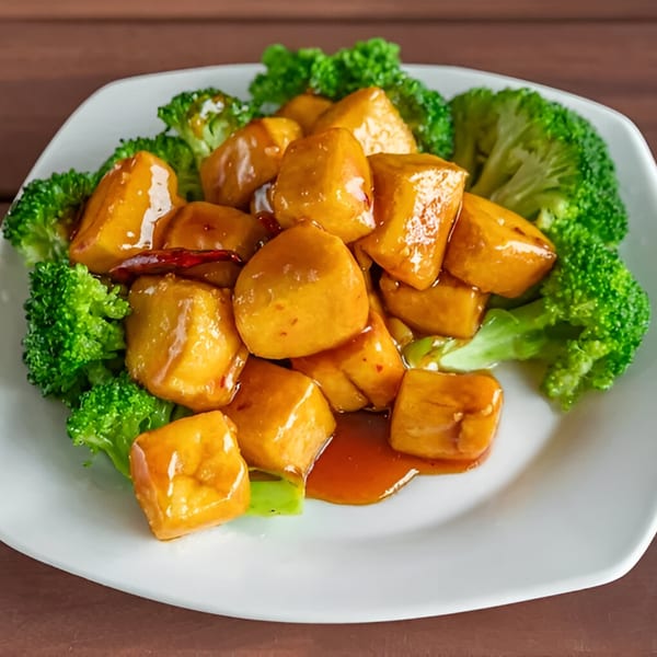 Wang Chinese Restaurant's General Tso's Tofu with broccoli florets on a white plate.