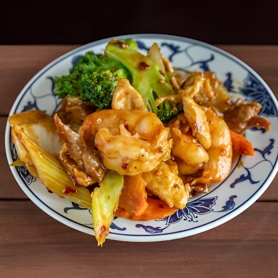 Wang Chinese Restaurant's shrimp and chicken stir-fry with broccoli, carrots, and celery on a decorative plate.